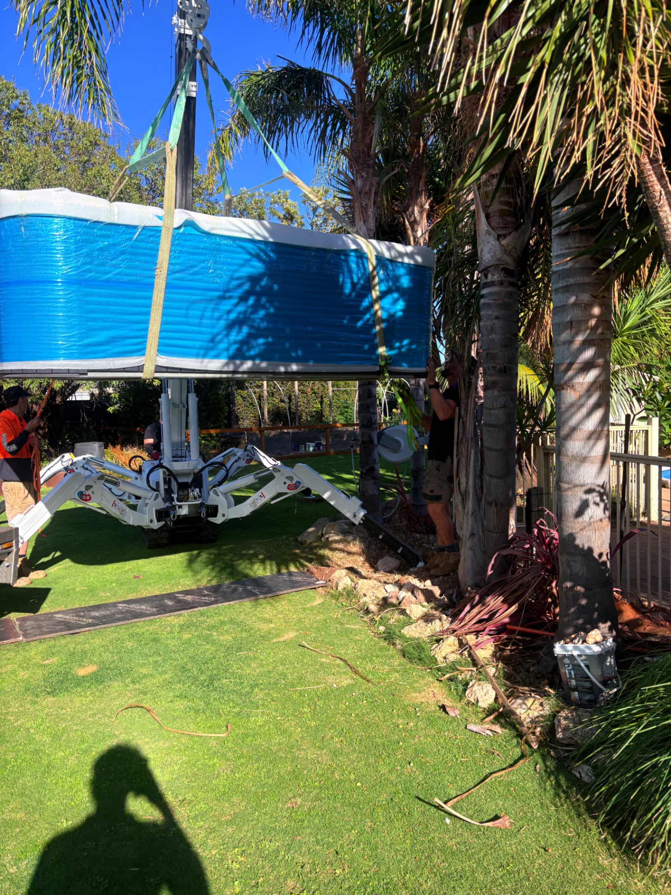 Swim spa being craned into a garden